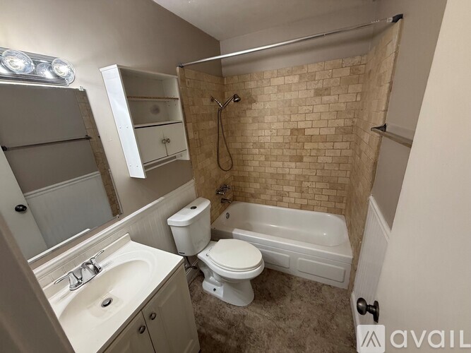 A bathroom with a toilet, sink, and bathtub.