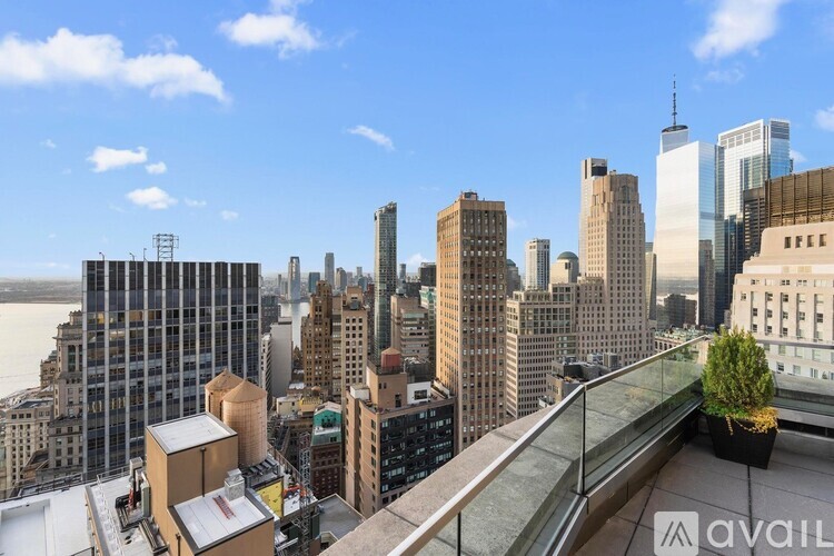 A cityscape with a river in the background and a building with the word "AVAILABLE" on it.
