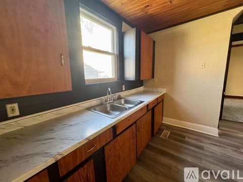 A kitchen with wooden cabinets and a marble countertop.