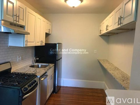 A kitchen with white cabinets and a black stove top oven.