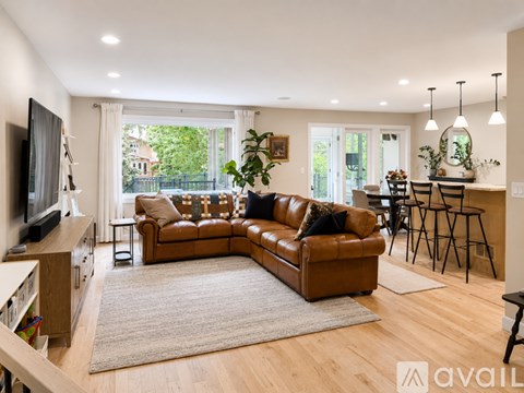 A living room with a brown leather couch and a flat screen TV.