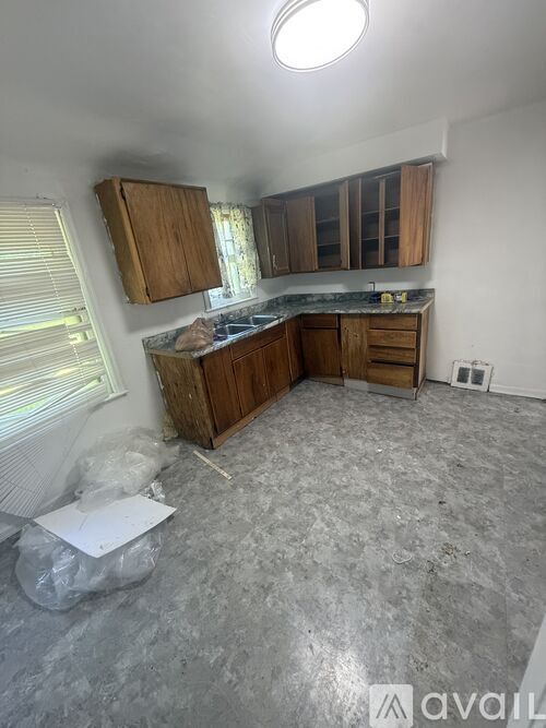 A kitchen with a granite countertop and wooden cabinets.