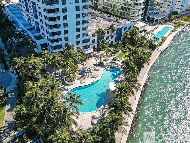 A swimming pool surrounded by palm trees and buildings.