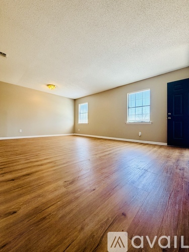 A room with wooden flooring and a window.