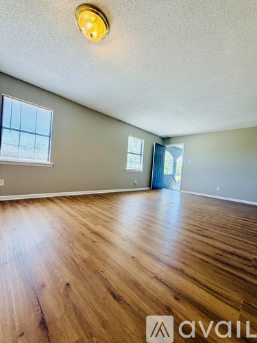 A room with wooden flooring and a window.
