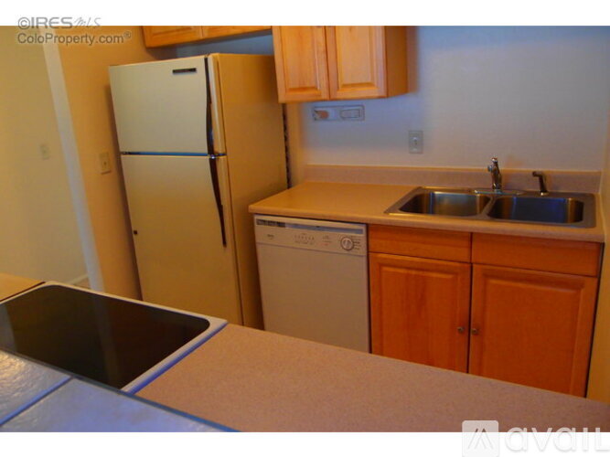 A kitchen with a refrigerator, dishwasher, and sink.