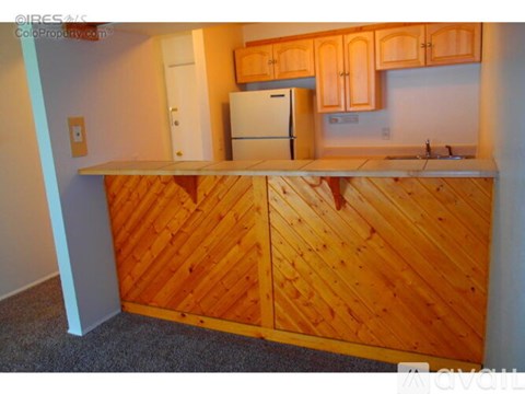 A kitchen with wooden cabinets and a white fridge.