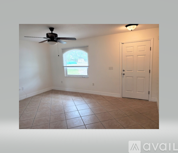 A room with a ceiling fan and a door.