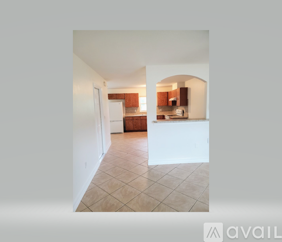 A kitchen with white appliances and brown cabinets.