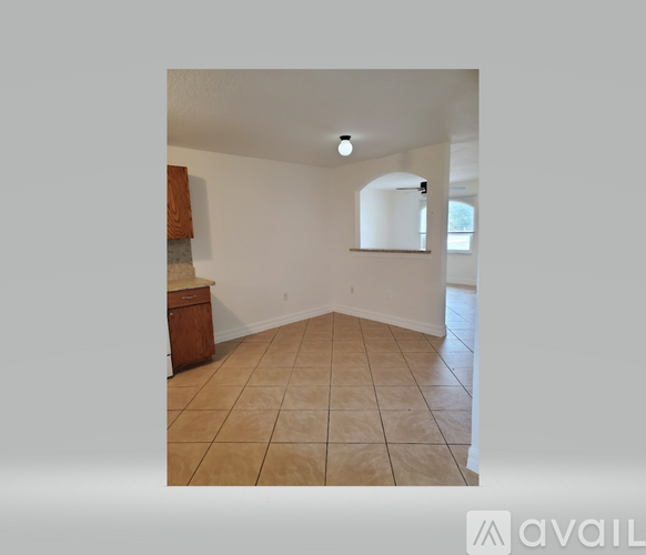 A room with a brown cabinet and a white wall with a mirror on it.