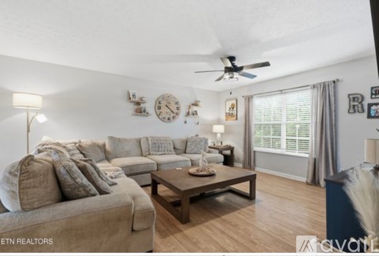 A living room with a beige couch and a wooden coffee table.