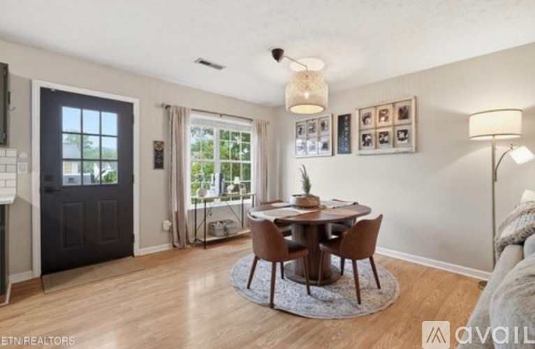 A dining room with a round table and chairs.