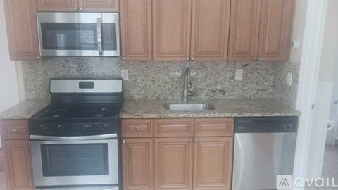 A kitchen with wooden cabinets and granite countertops.
