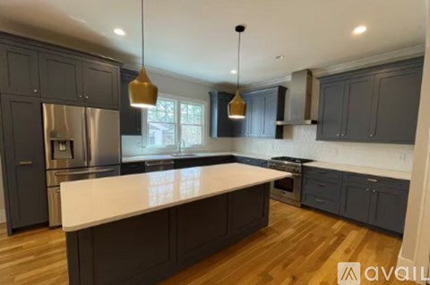 A kitchen with dark cabinets and a white countertop.