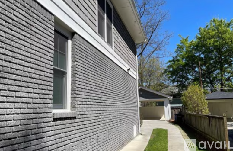 A house with a grey brick exterior is for sale.