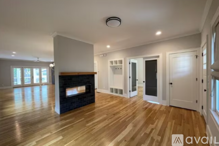 A spacious living room with a fireplace and wooden flooring.