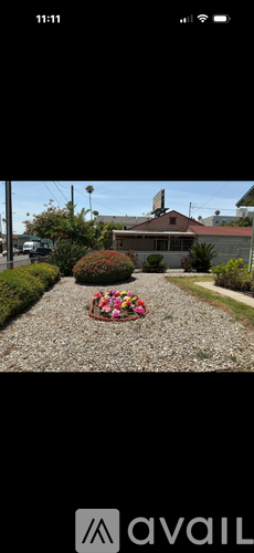 A house with a gravel driveway and a flower bed in front.