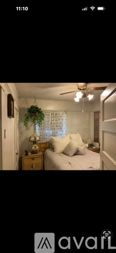 A bedroom with a bed, nightstand, and a ceiling fan.