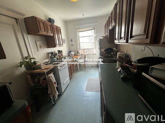 A kitchen with brown cabinets and a black countertop.