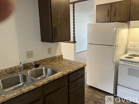 A kitchen with a granite countertop and a white refrigerator.