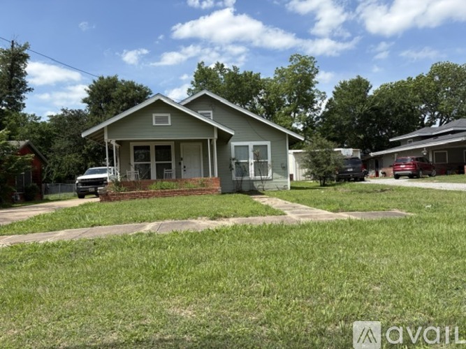 A house with a green lawn in front of it.
