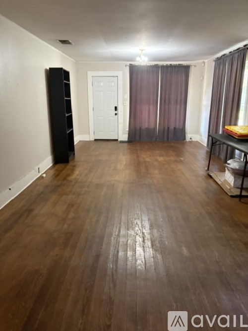A room with wooden flooring and a white door.