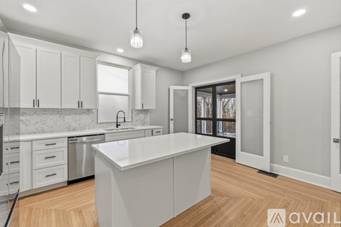 A modern kitchen with white cabinets and a central island.