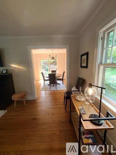 A living room with a wooden floor and a table with a lamp on it.