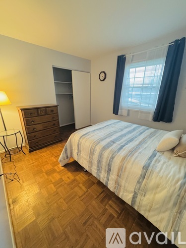 A bedroom with a bed, nightstand, and wardrobe.
