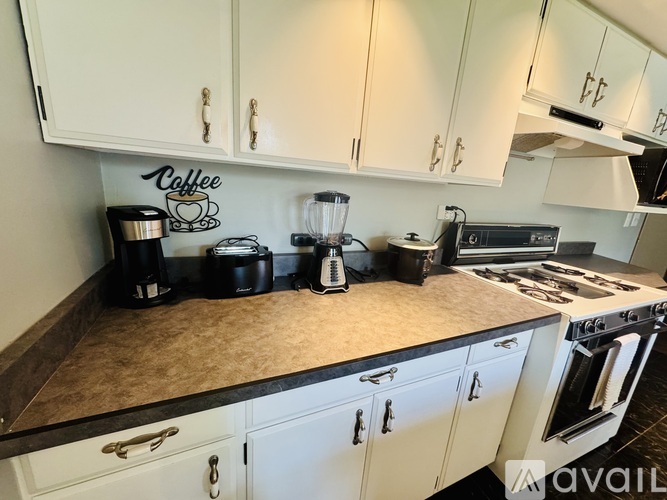 A kitchen with a coffee sign on the wall.