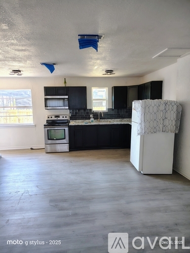 A kitchen with a white fridge and black cabinets.