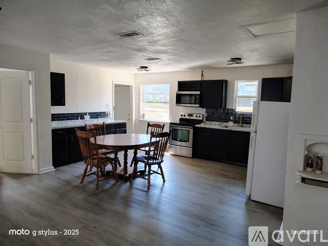 A kitchen with a table and chairs in the middle of the room.