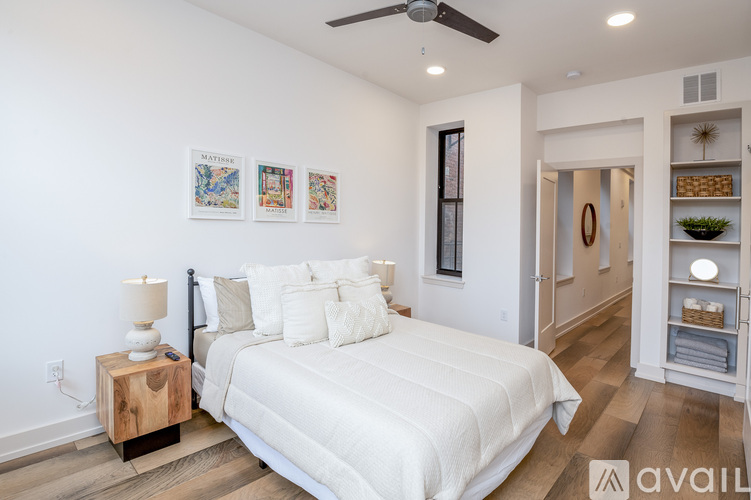 A bedroom with a large bed and a wooden side table.