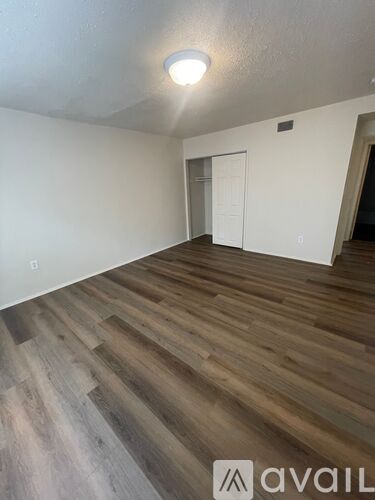 A room with wooden flooring and a white door.