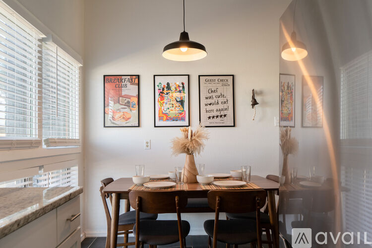 A dining room with a table set for two and a guest check on the wall.