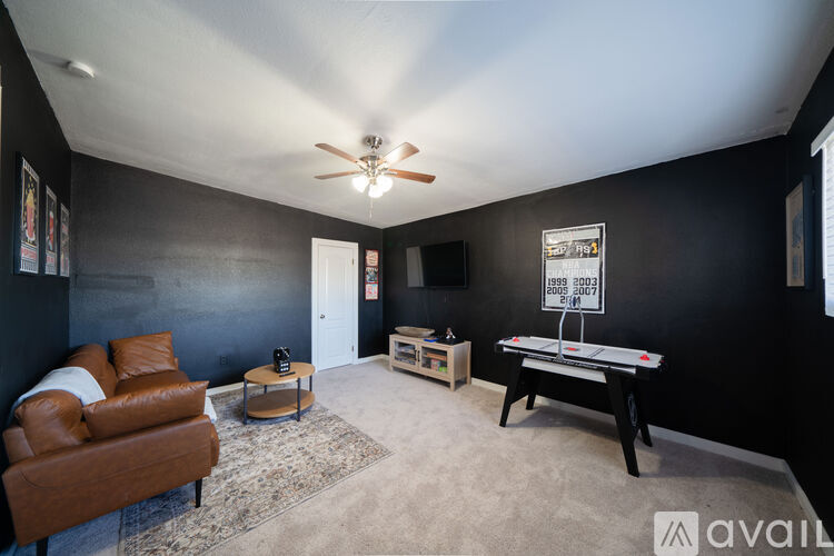 A room with a brown leather couch, a coffee table, and a pool table.