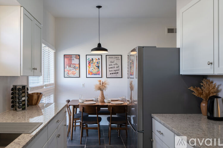A kitchen with a table and chairs in the middle of it.