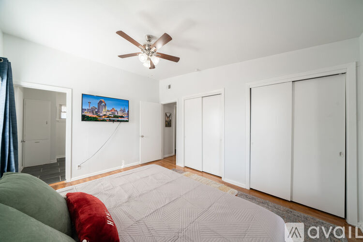 A living room with a ceiling fan and a painting hanging on the wall.