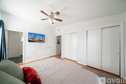 A living room with a ceiling fan and a painting hanging on the wall.