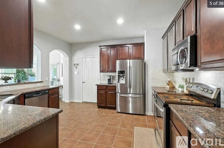 A kitchen with brown cabinets and a refrigerator.
