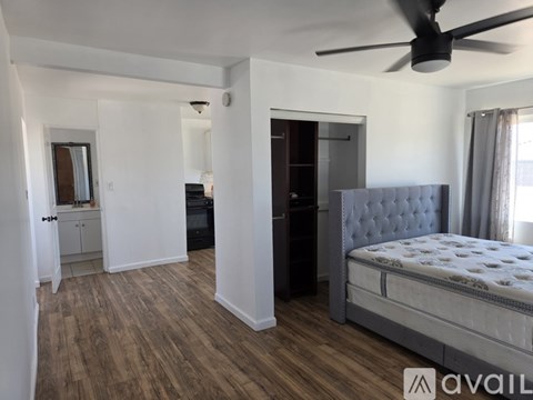 A bedroom with a bed, dresser, and mirror.