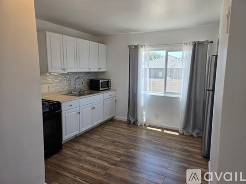 A kitchen with white cabinets and a black dishwasher.