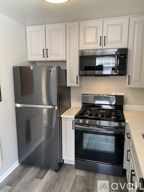 A kitchen with a stainless steel refrigerator, oven, and cabinets.