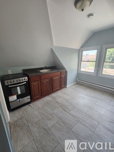 A kitchen area with a stove top oven and a cabinet.