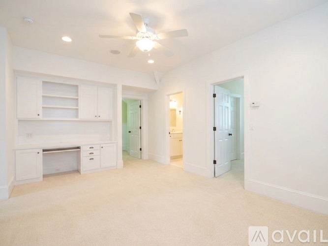 A spacious room with a desk and drawers.
