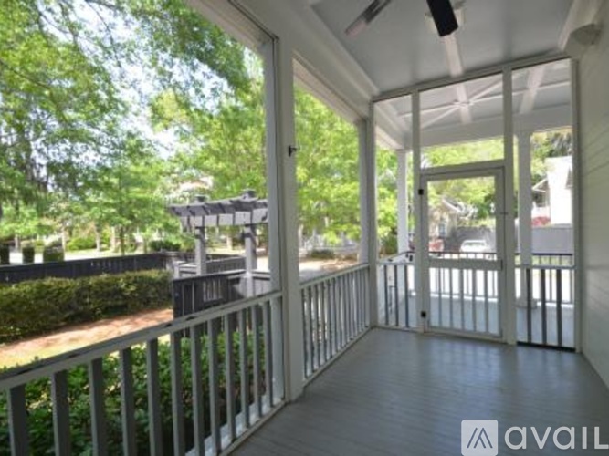 A balcony with a railing and a view of trees and a building.
