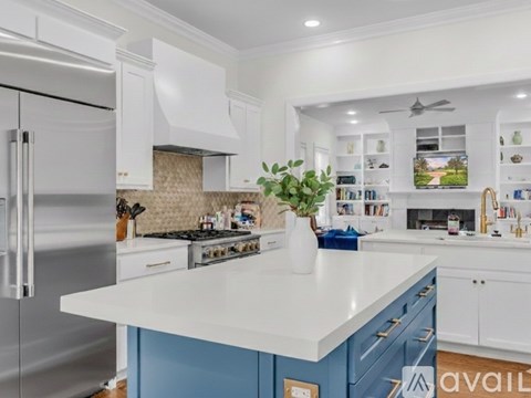 A kitchen with a white countertop and blue cabinets.
