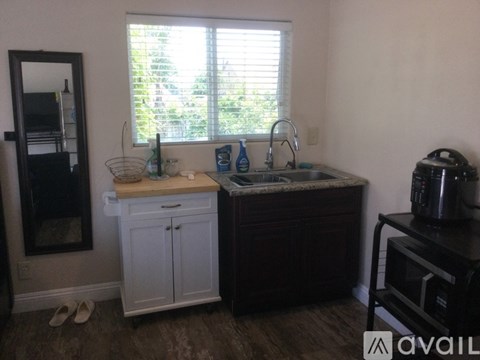A kitchen with white cabinets and a wooden counter.