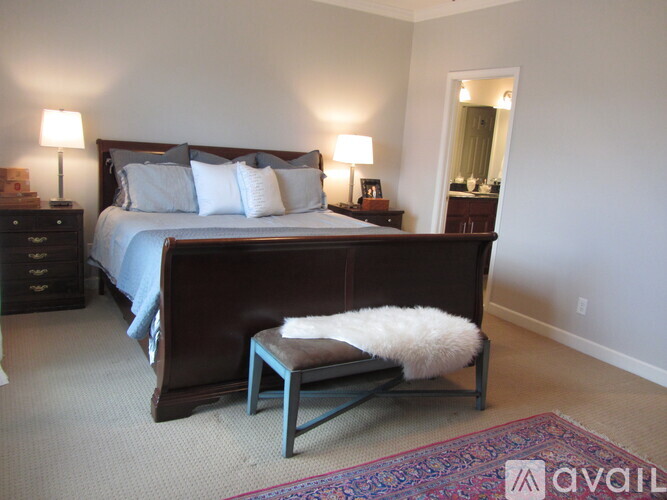 A bedroom with a large bed and a bench in front of it.