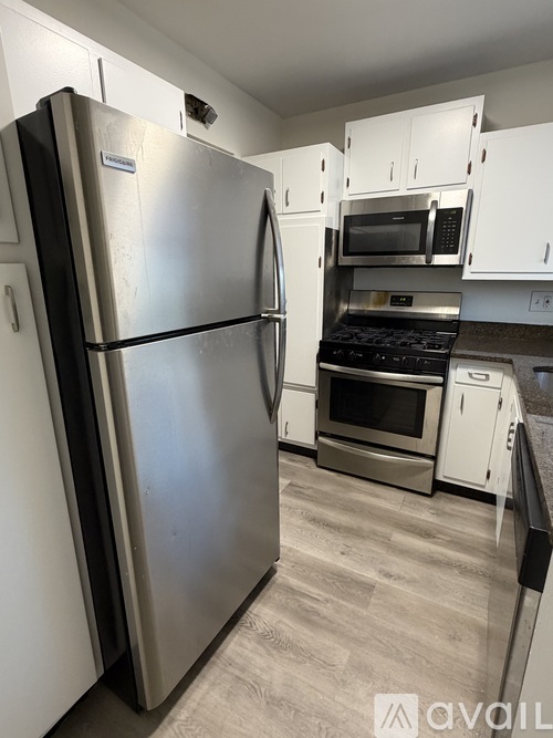 A kitchen with a stainless steel refrigerator and microwave.